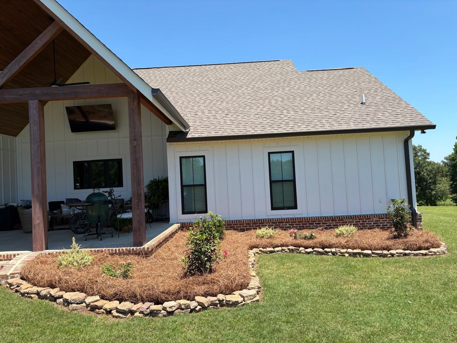 Fresh pine straw installed in a landscaped flower bed